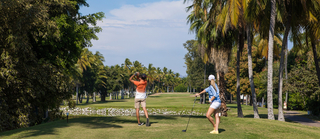 A couple playing golf at El Cid Golf & Country Club